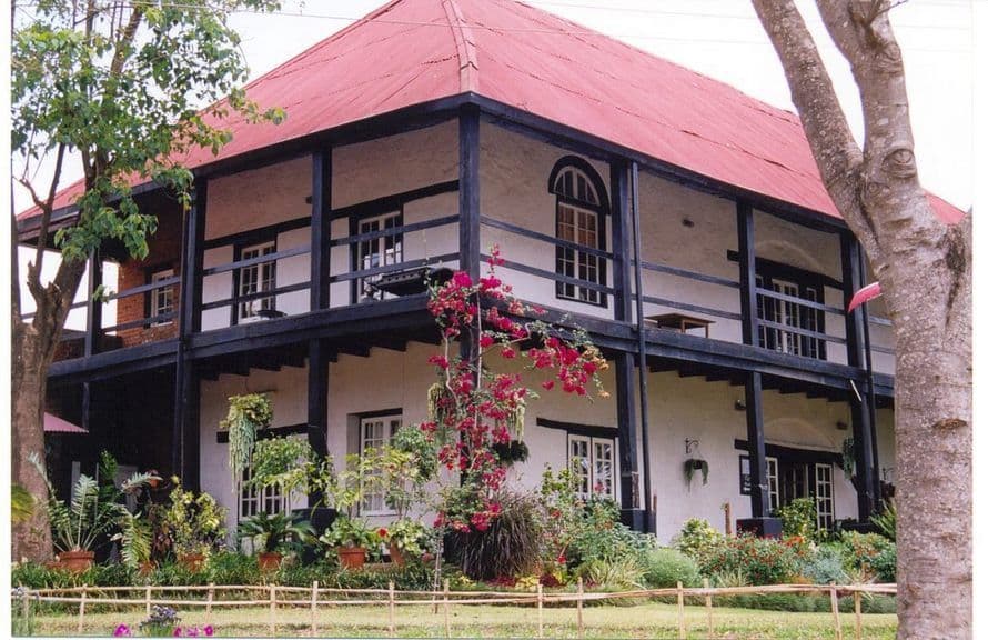 Historic colonial-style house with red roof and garden in Malawi