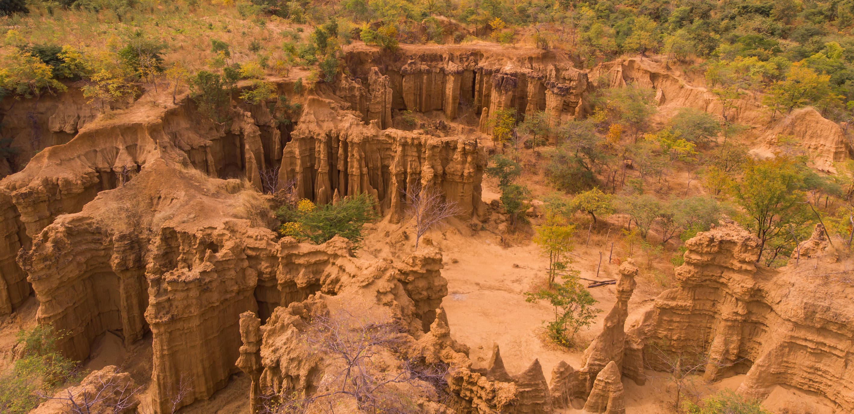 Majestic view of the Mzuzu Earth Pyramids in Malawi with rugged cliffs and golden rock formations.